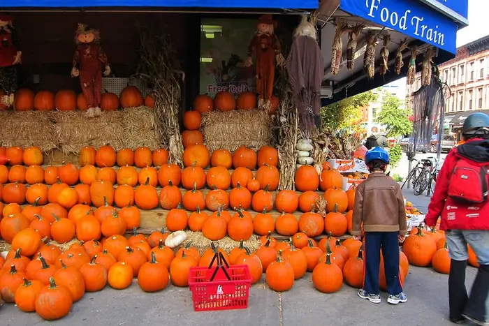 This is a photo of a bunch of pumpkins outside a corner store.